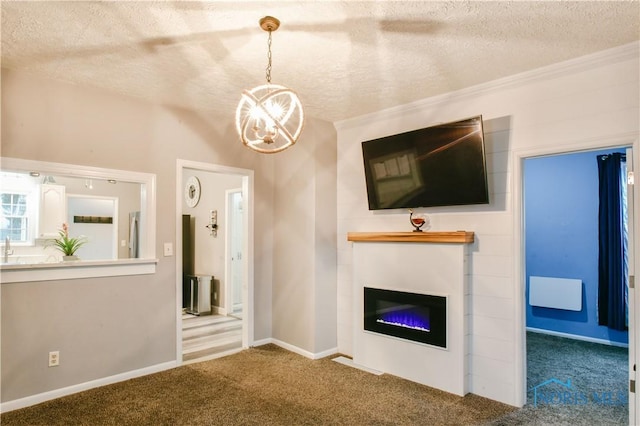 unfurnished living room with carpet, a textured ceiling, an inviting chandelier, and ornamental molding