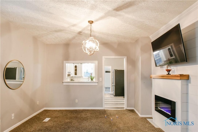 unfurnished living room featuring a chandelier, carpet, and a textured ceiling