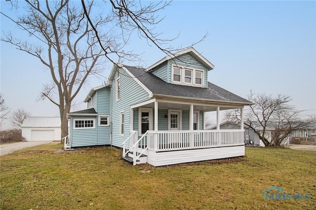 view of front facade featuring a front yard, an outbuilding, a garage, and covered porch