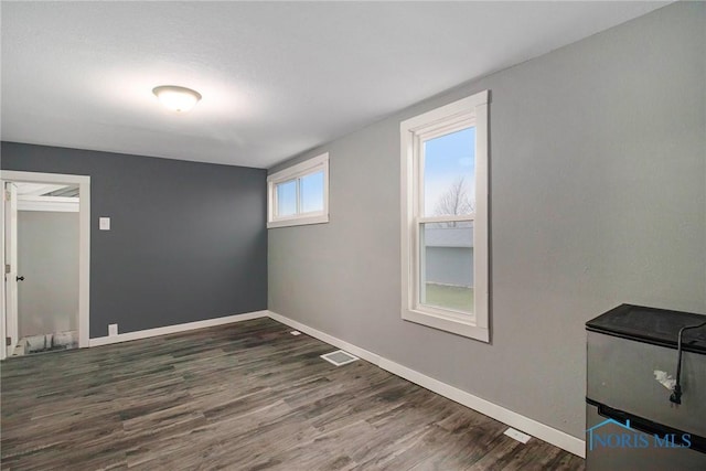 unfurnished room with dark wood-type flooring