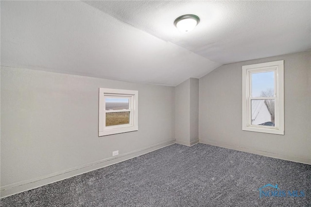 bonus room with a textured ceiling, carpet, and vaulted ceiling