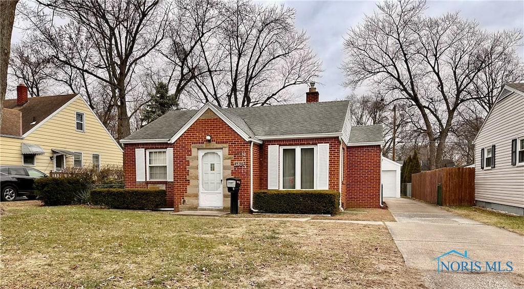 view of front of property featuring a garage, an outdoor structure, and a front yard