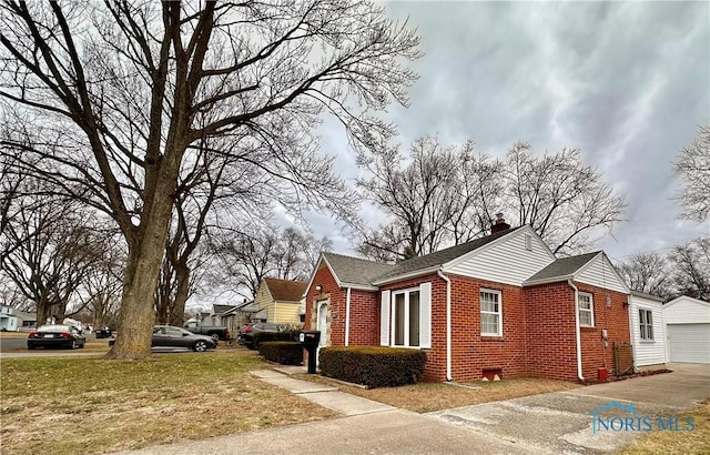 view of side of property with a garage and a lawn