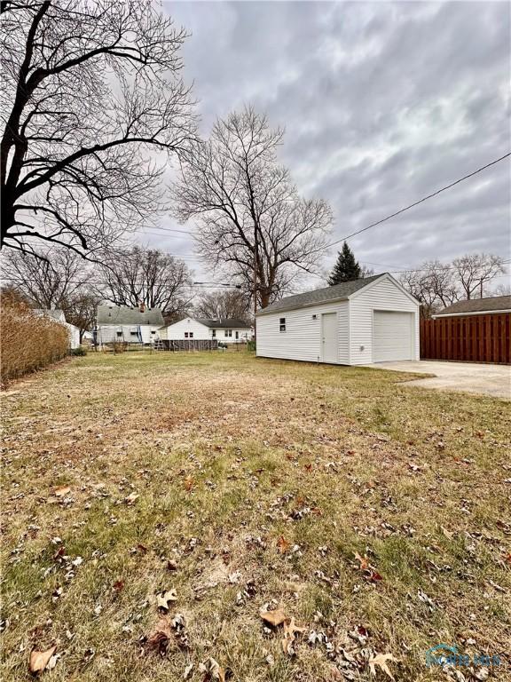 view of yard with a garage and an outbuilding