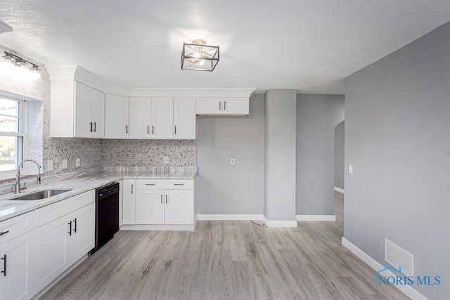 kitchen with dishwasher, white cabinets, light stone counters, and sink