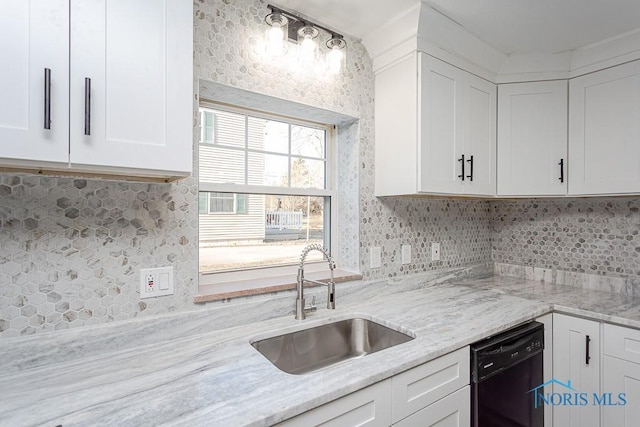 kitchen featuring dishwasher, light stone counters, white cabinetry, and sink