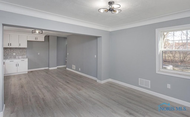 interior space featuring light wood-type flooring and an inviting chandelier