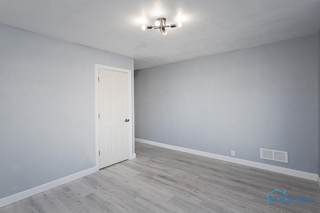 unfurnished room with light wood-type flooring