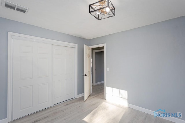 unfurnished bedroom featuring light hardwood / wood-style flooring and a closet