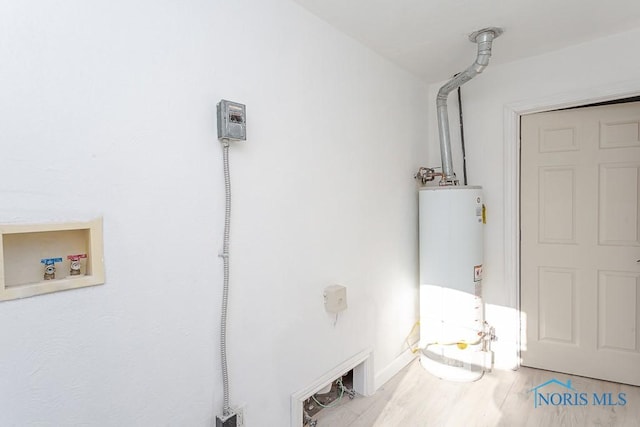 laundry room featuring washer hookup, light hardwood / wood-style floors, and gas water heater