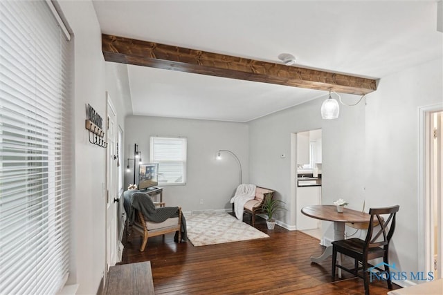 sitting room featuring beamed ceiling and dark wood-type flooring