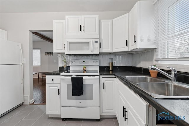 kitchen with white cabinets, light tile patterned flooring, white appliances, and sink