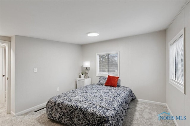 bedroom with multiple windows and light carpet