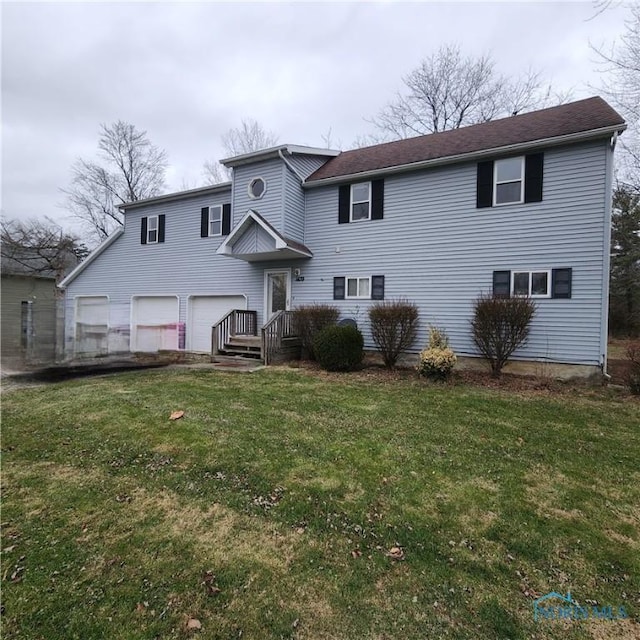 view of front of house with a garage and a front lawn