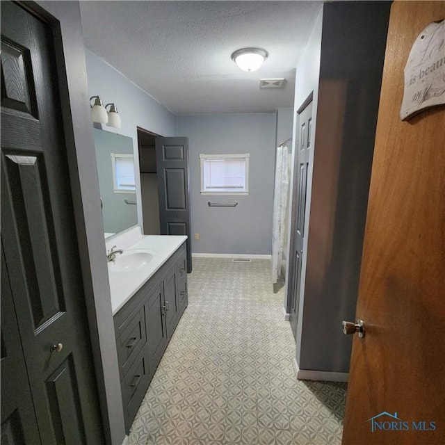 bathroom featuring a textured ceiling and vanity