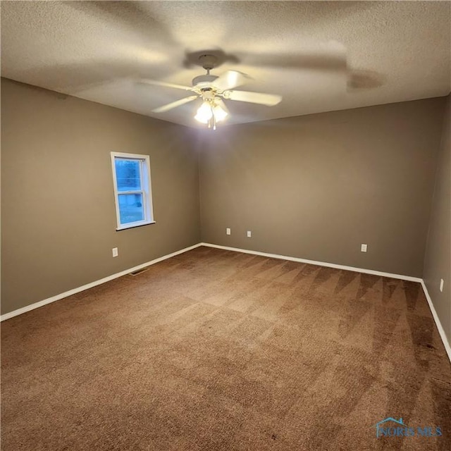 carpeted spare room featuring ceiling fan and a textured ceiling