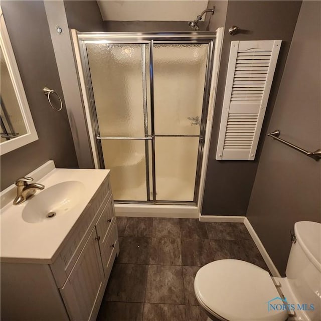 bathroom with vanity, an enclosed shower, and toilet