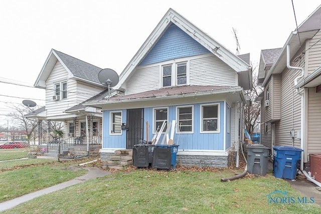 view of front of property featuring covered porch and a front yard