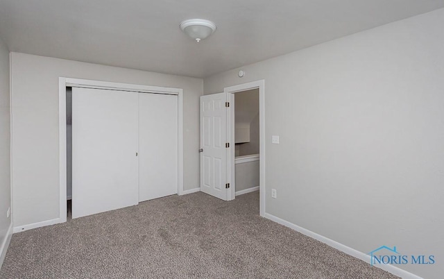 unfurnished bedroom featuring carpet and a closet