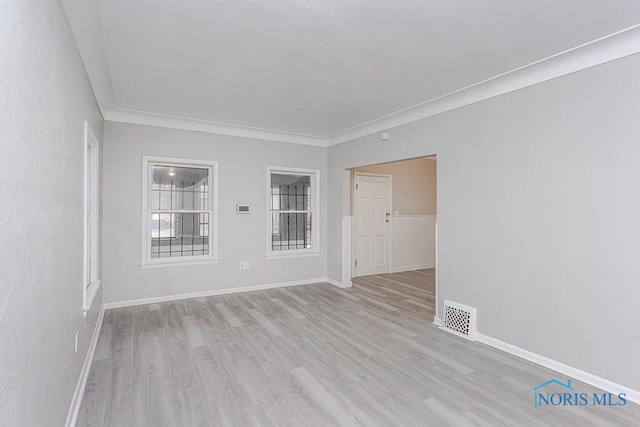 unfurnished room with crown molding and light hardwood / wood-style flooring