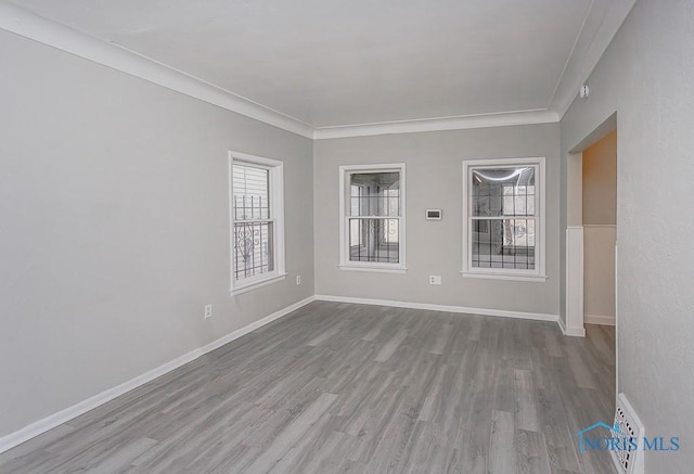 empty room featuring light hardwood / wood-style floors and crown molding