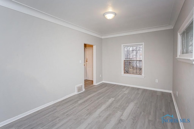 unfurnished room featuring crown molding and light hardwood / wood-style flooring