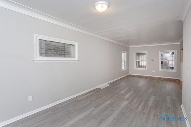 spare room featuring hardwood / wood-style flooring and crown molding