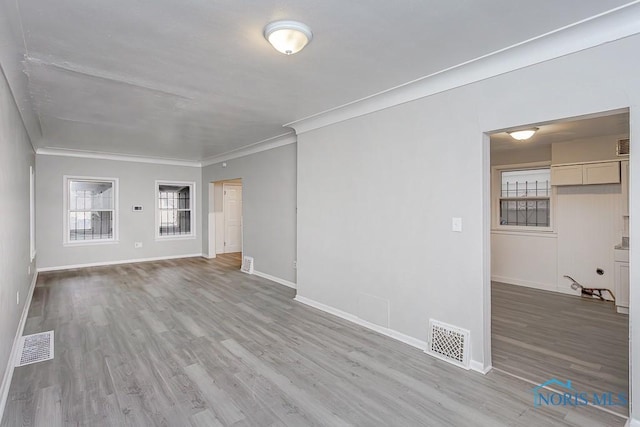 unfurnished living room featuring light hardwood / wood-style floors and ornamental molding