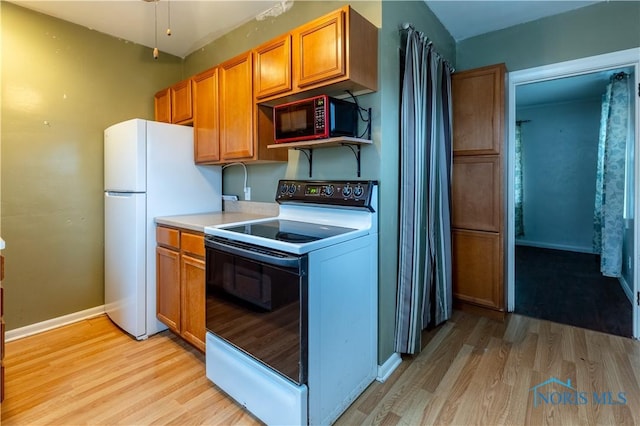 kitchen featuring white appliances and light hardwood / wood-style floors