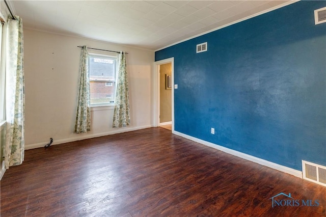 spare room with crown molding and dark wood-type flooring