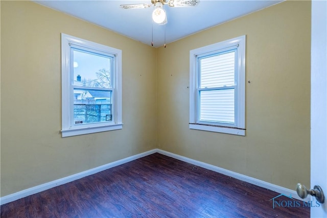 unfurnished room featuring a wealth of natural light, dark hardwood / wood-style flooring, and ceiling fan