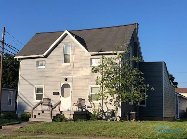 view of front of property with a front lawn and central air condition unit