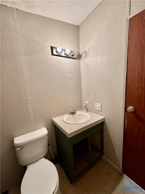 bathroom with vanity, a textured ceiling, and toilet