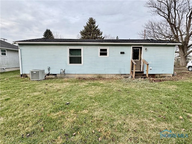 back of property featuring a lawn and central AC