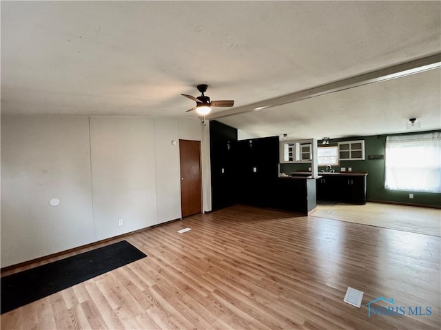 unfurnished living room featuring hardwood / wood-style floors, ceiling fan, and lofted ceiling