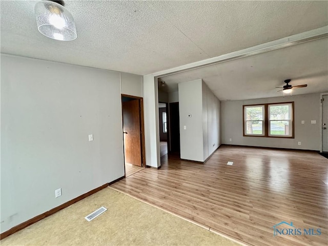 spare room with hardwood / wood-style floors, a textured ceiling, and ceiling fan