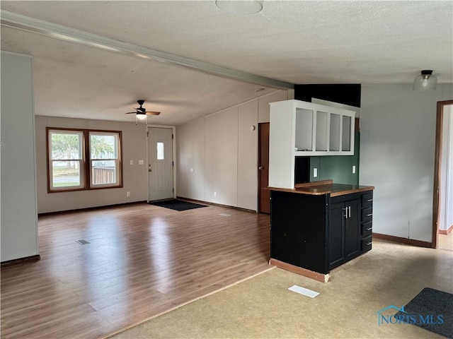 kitchen with vaulted ceiling with beams, ceiling fan, and light wood-type flooring