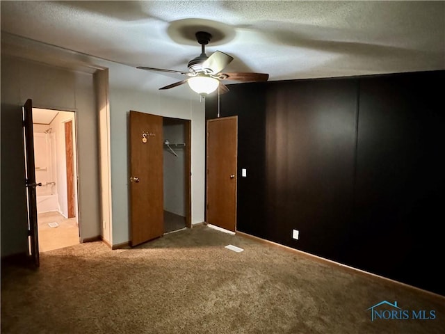 unfurnished bedroom featuring ceiling fan, a closet, carpet floors, and a textured ceiling