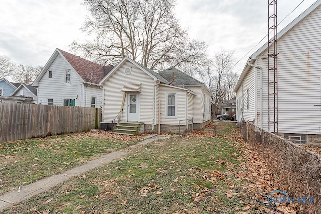 bungalow-style home featuring central AC unit and a front yard