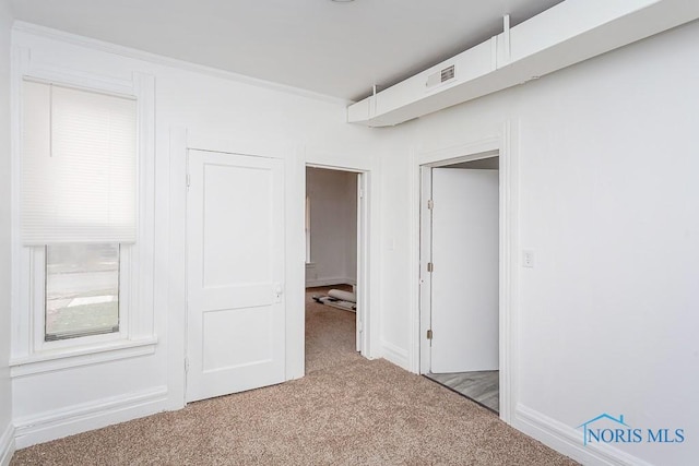 unfurnished bedroom with light colored carpet