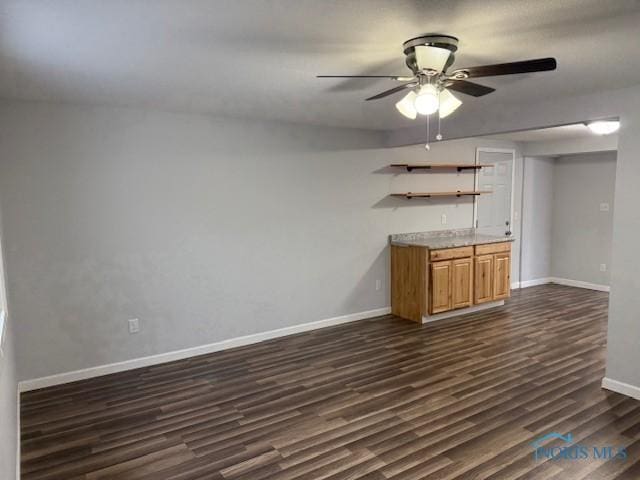 bar featuring ceiling fan and dark hardwood / wood-style flooring