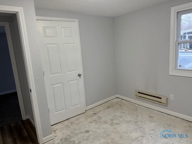 unfurnished room featuring a baseboard heating unit