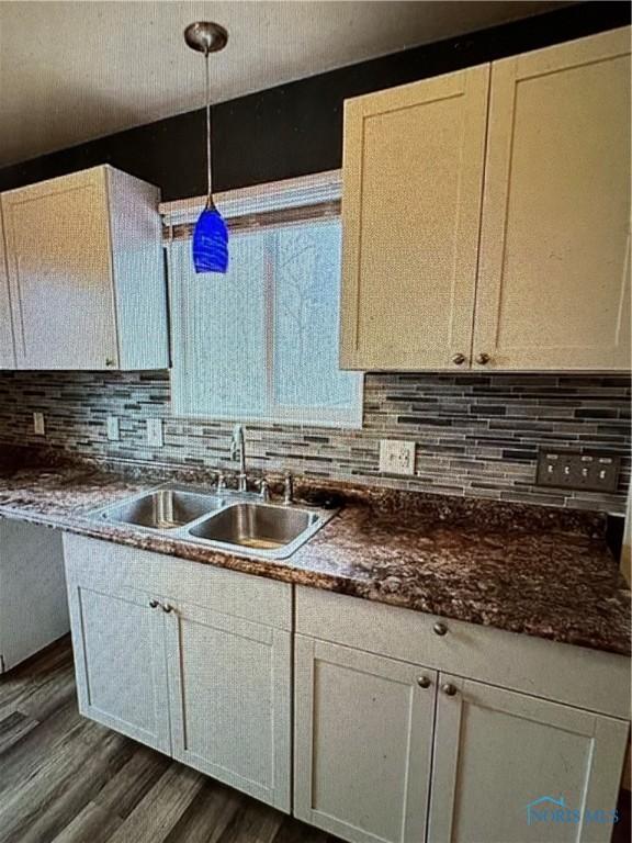 kitchen with decorative light fixtures, dark hardwood / wood-style flooring, decorative backsplash, and sink