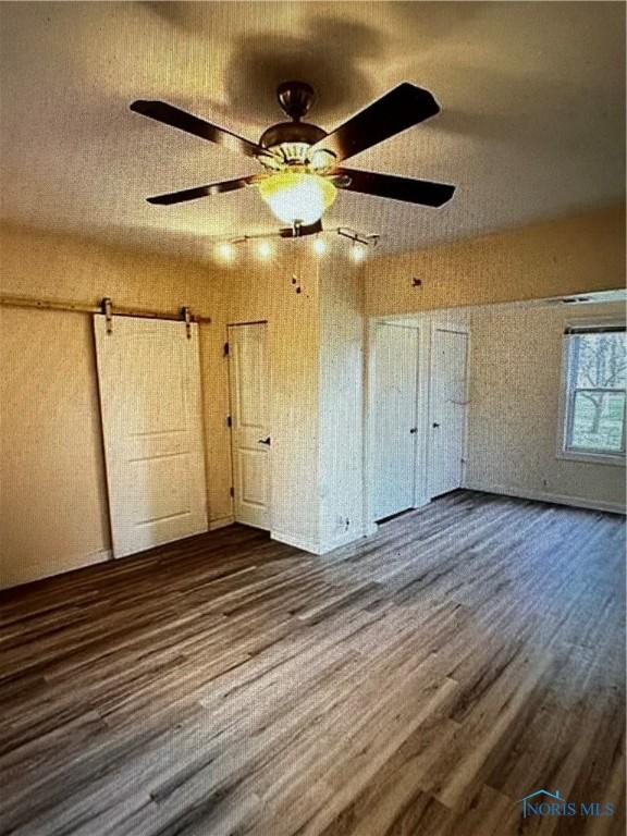 unfurnished bedroom with dark hardwood / wood-style floors and ceiling fan