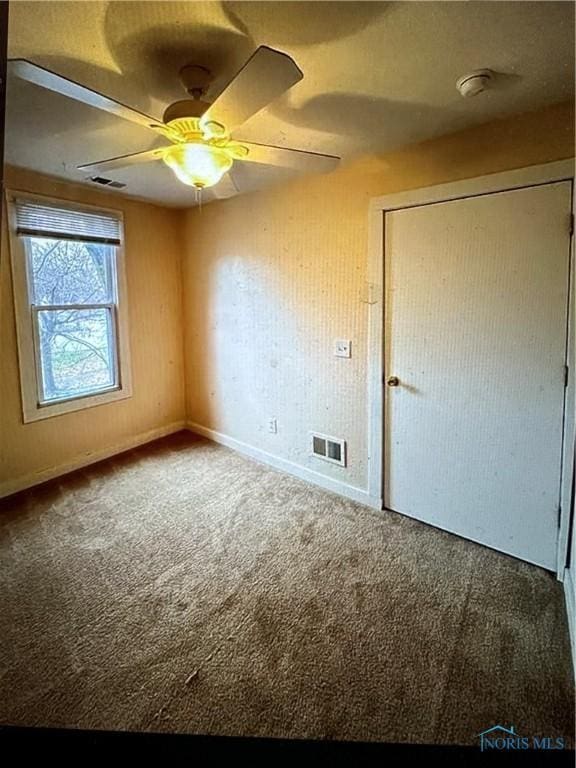 carpeted empty room featuring ceiling fan