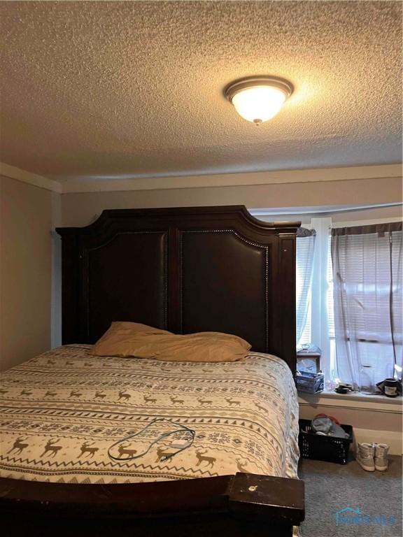 carpeted bedroom featuring a textured ceiling