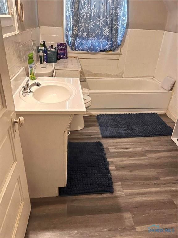 full bathroom with wood-type flooring, vanity, toilet, and  shower combination