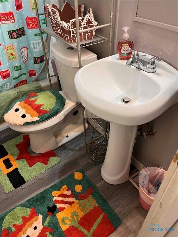 bathroom featuring hardwood / wood-style flooring and toilet