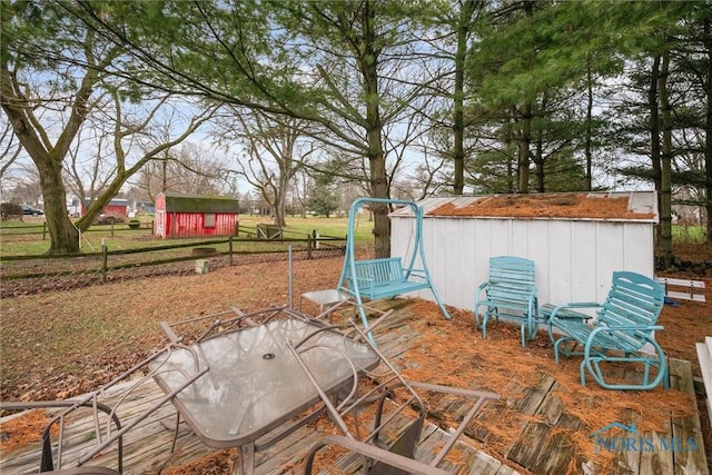 view of patio / terrace featuring a storage shed, an outbuilding, and outdoor dining space