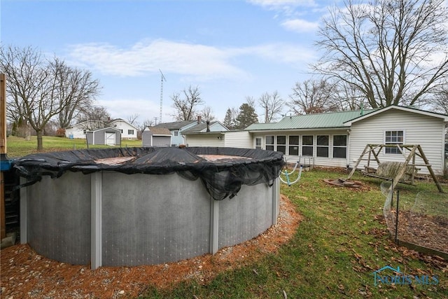 view of pool with a covered pool, a lawn, and a sunroom